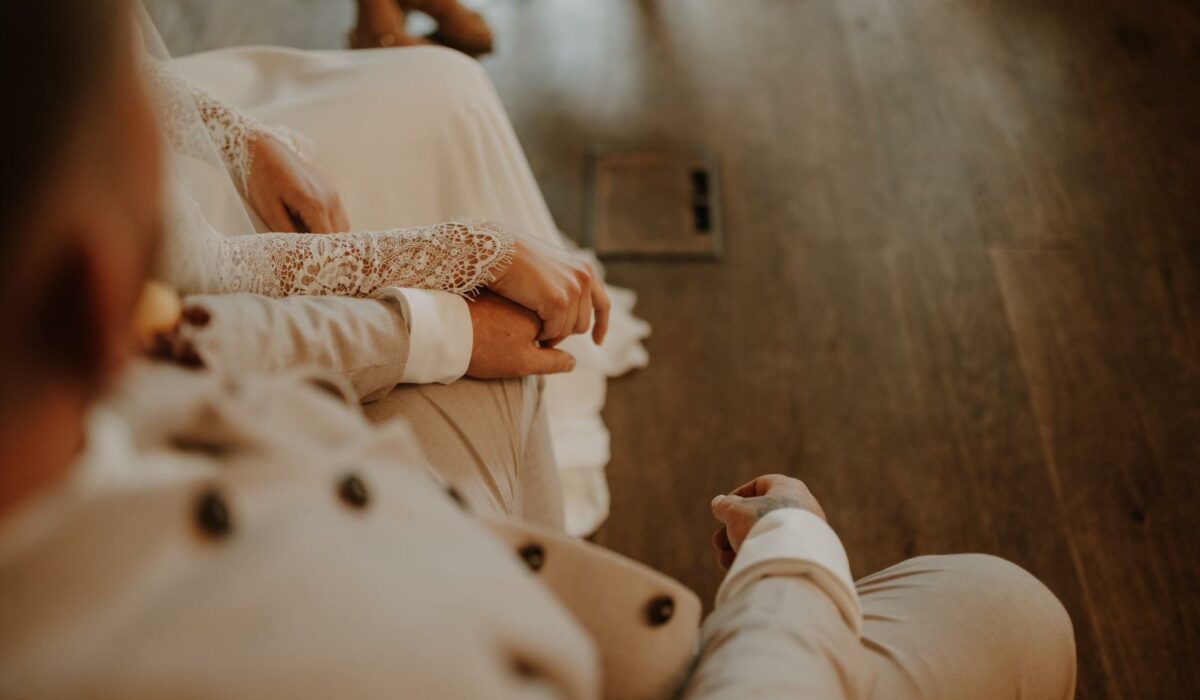 Blogbeitrag | Brautpaar sitzt und hält Hände