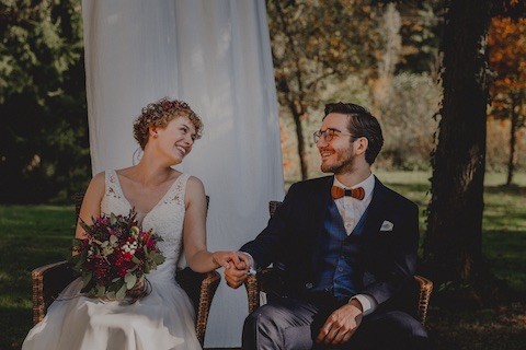 Brautpaar bei einer freien Trauung, sitzen auf den Stühlen und freuen sich