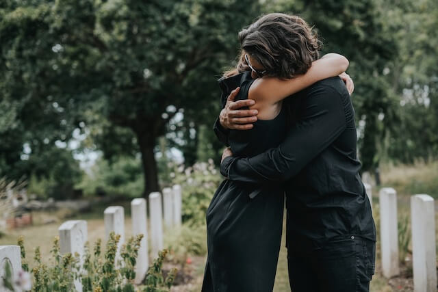 Trauerredner | Trauergäste umarmen sich