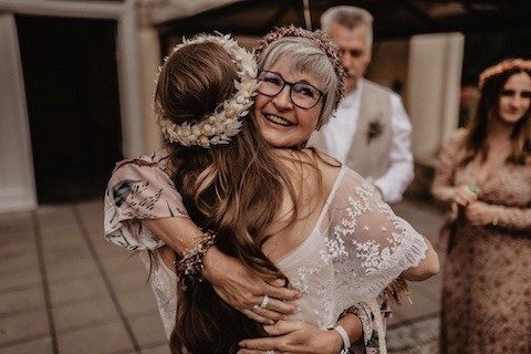 Braut wird von Gast umarmt