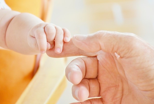 Babyhand mit Papahand