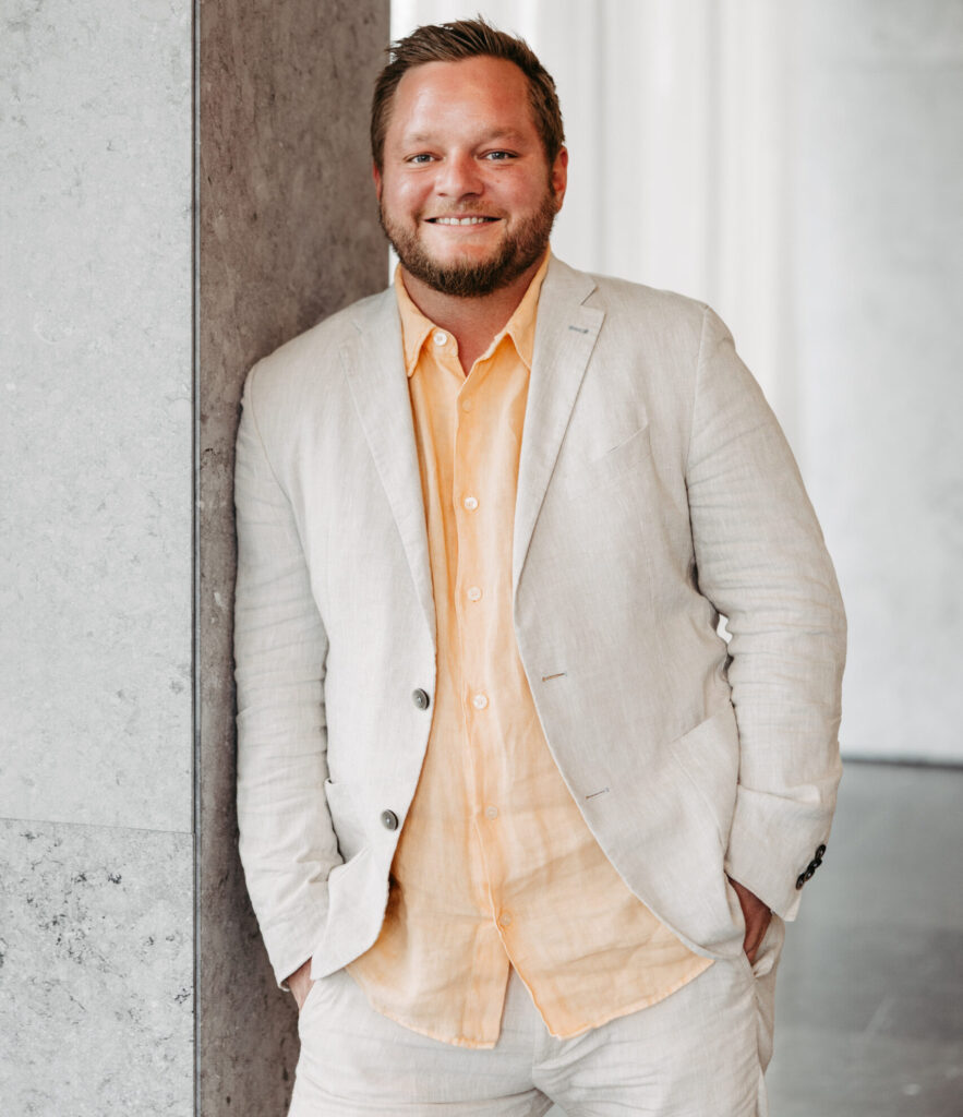 Trauredner Tom Salzlechner locker angelehnt an einer Wand