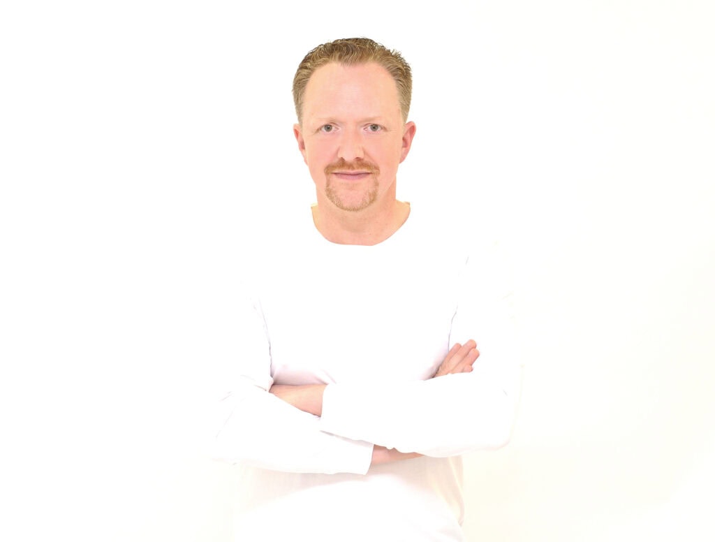 Portrait eines Mannes mit Armkreuz, professionell, freundlich, auf weißem Hintergrund, geeignet für Redner, Moderatoren, Sprecher, Event- und Hochzeitsredner.