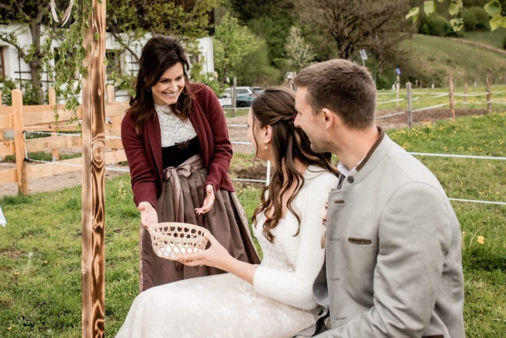 Hochzeitsredner bei einer emotionalen Zeremonie im Freien, die von einem professionellen Redner gehalten wird, um eine unvergessliche Trauung im Grünen zu gewährleisten.