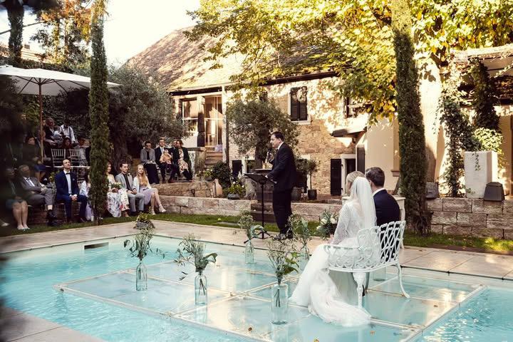 Hochzeitszeremonie im Freien mit einem freien Redner, der eine persönliche Trauung am Pool in einem Garten durchführt. Perfekt für individuelle Hochzeiten und unvergessliche Momente.