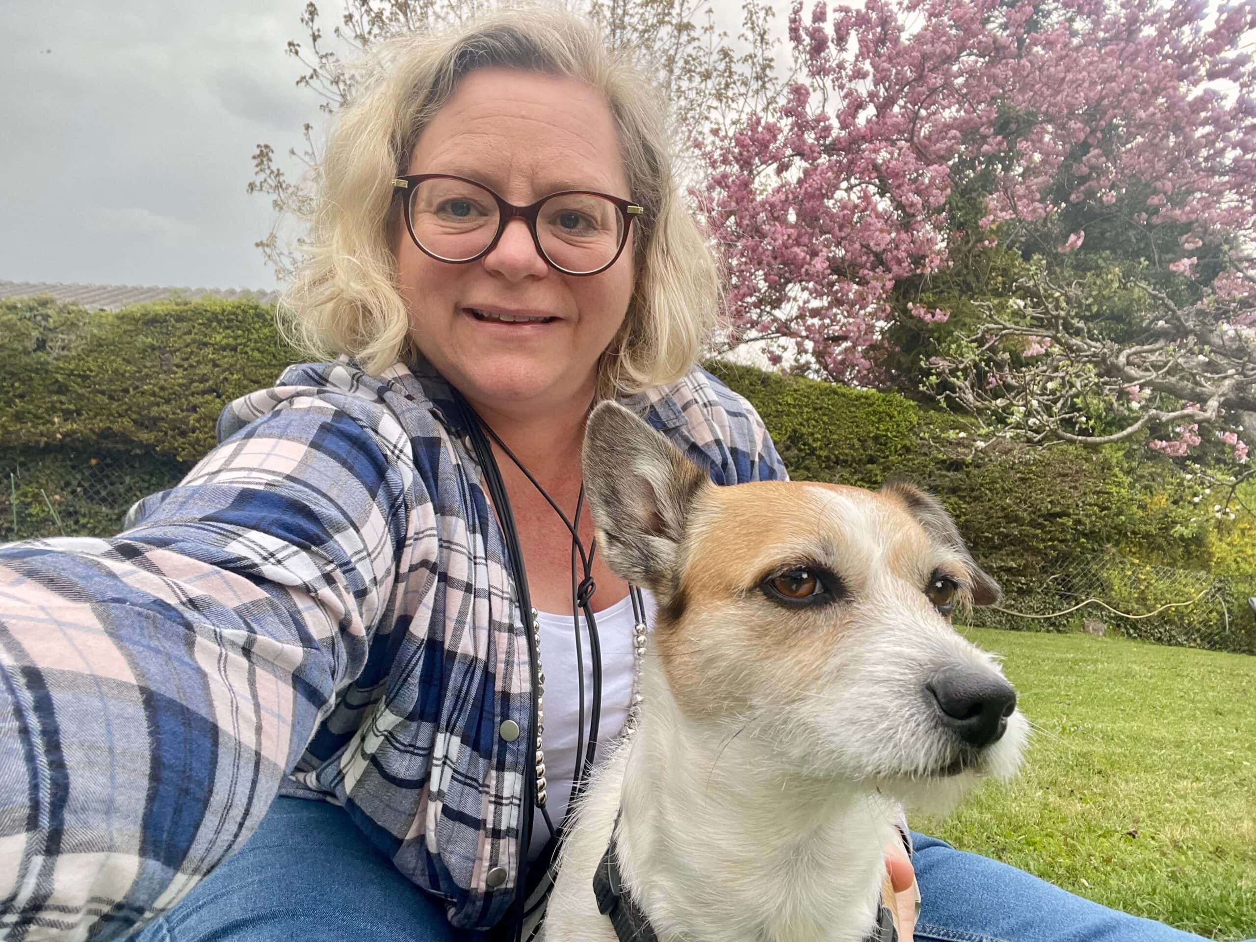 Sigrid Sudi mit Hund im Grünen, bei blühendem Baum, bei einem öffentlichen Redner-Event.