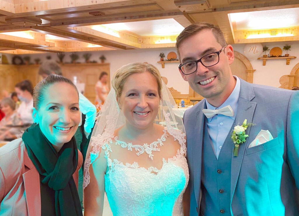 Glückliches Brautpaar mit Redner bei einer Hochzeit, die von Freie Redner organisiert wurde, in einer gemütlichen, rustikalen Location.