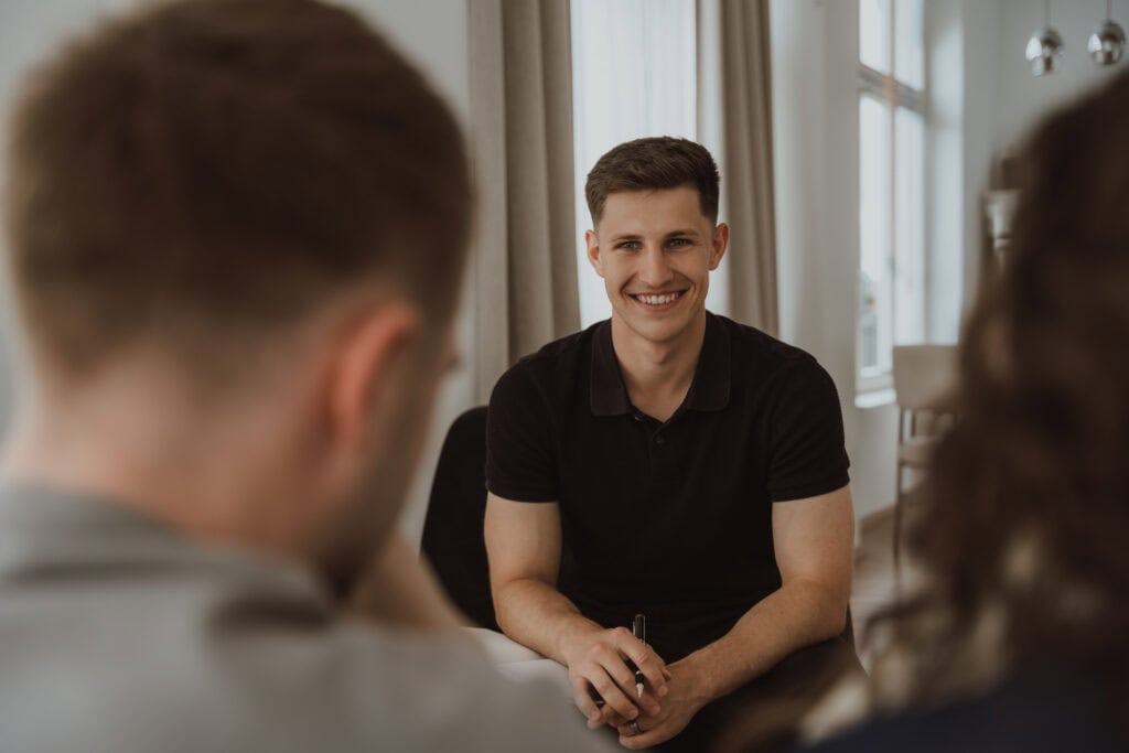 Freier Redner spricht bei einem Beratungsgespräch mit Klienten, vermittelt Vertrauen und Professionalität im Bereich öffentliches Reden und Moderation.