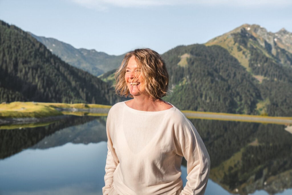 Freie Rednerin vor malerischer Bergkulisse mit See, ideal für Redner, Motivationsredner, Speaker, Coach, Trainer, Berater, Referent, Moderator, Trainerin, Speakerin, Coach, Rednerin, Motivationsredner.