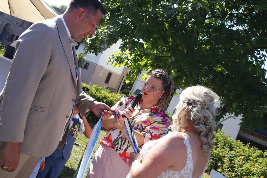 Traurednerin Anna Gasteier begleitet Handfasting-Ritual im Rahmen einer Freien Trauung