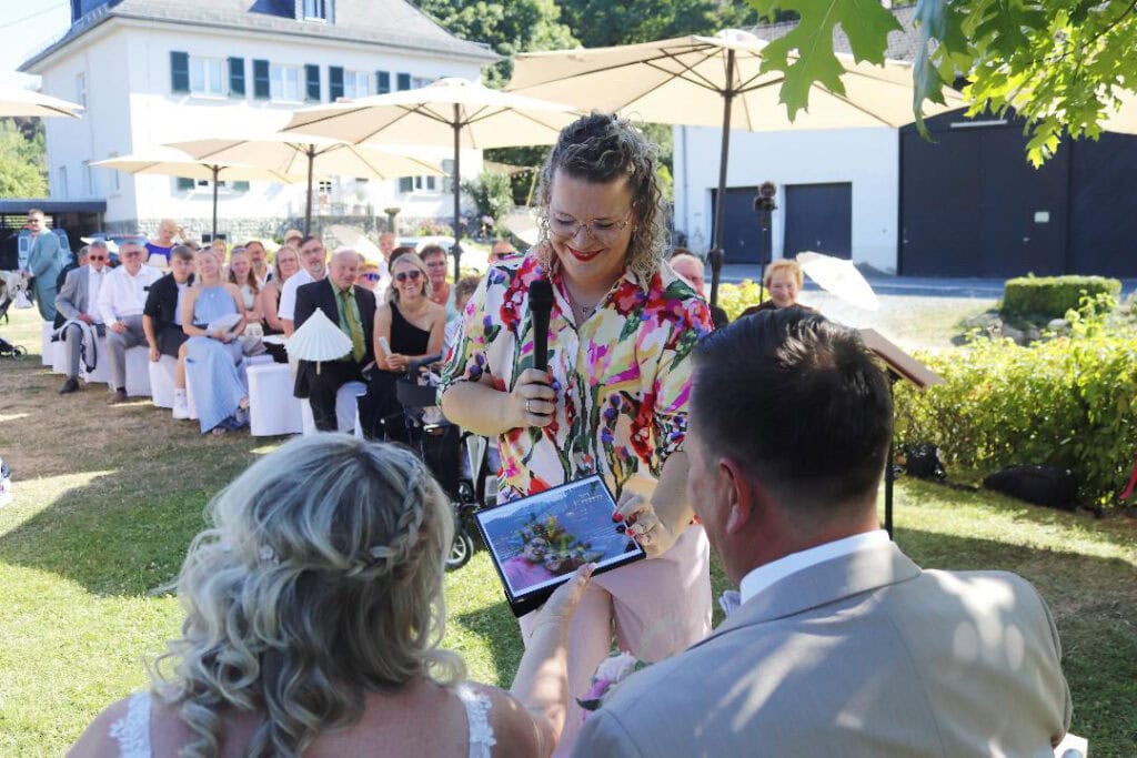 Traurednerin Anna Gasteier überreicht Bild an Hochzeitspaar