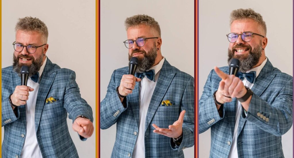 Freier Redner bei einer Rede, trägt Brille, graues Haar, blauer Anzug mit Krawatte, spricht in Mikrofon, vor neutralem Hintergrund.